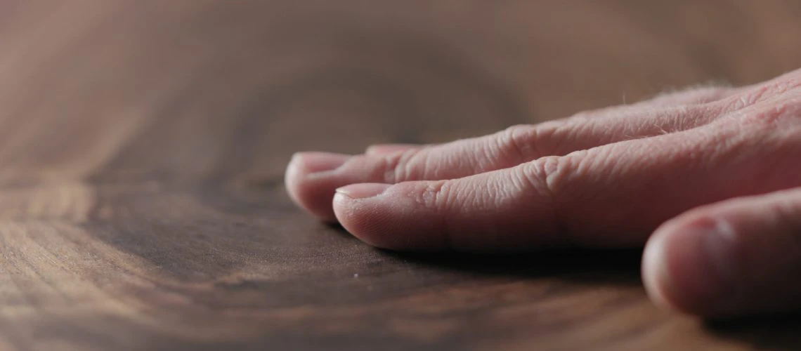 Hand on Wooden Counter