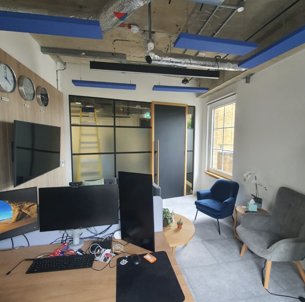 Acoustic panelling | Blue floating acoustic panels hanging from the ceiling of a modern office space. 